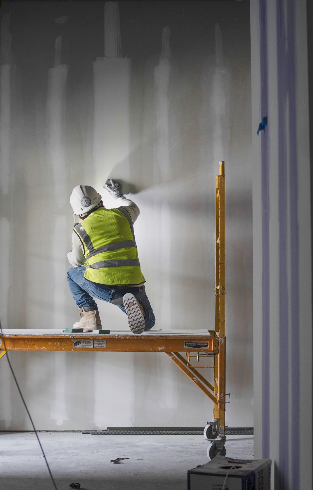 Finisher checking a Level 5 drywall surface under raking flashlight